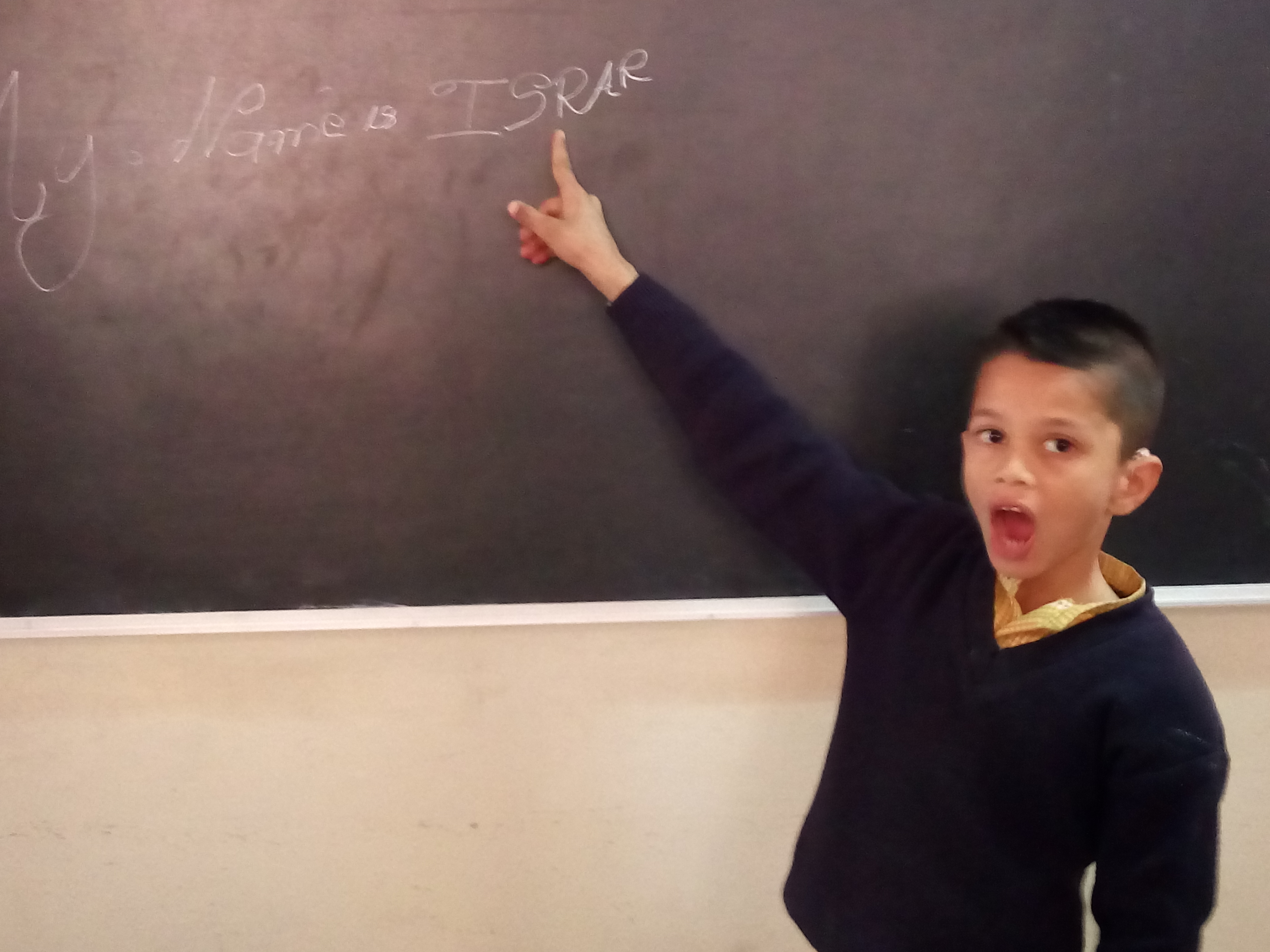Hearing Impaired child writing his name